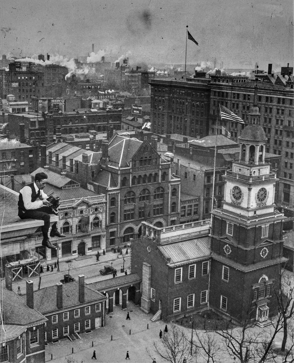 Walter Crail sits perched upon the ledge of the Public Ledger Building while taking photos of Independence Hall - 1917 The Evening Public Ledger